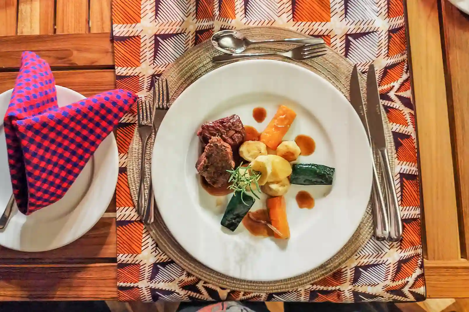 Elegantly plated grilled meat with roasted vegetables and artistic sauce presentation
