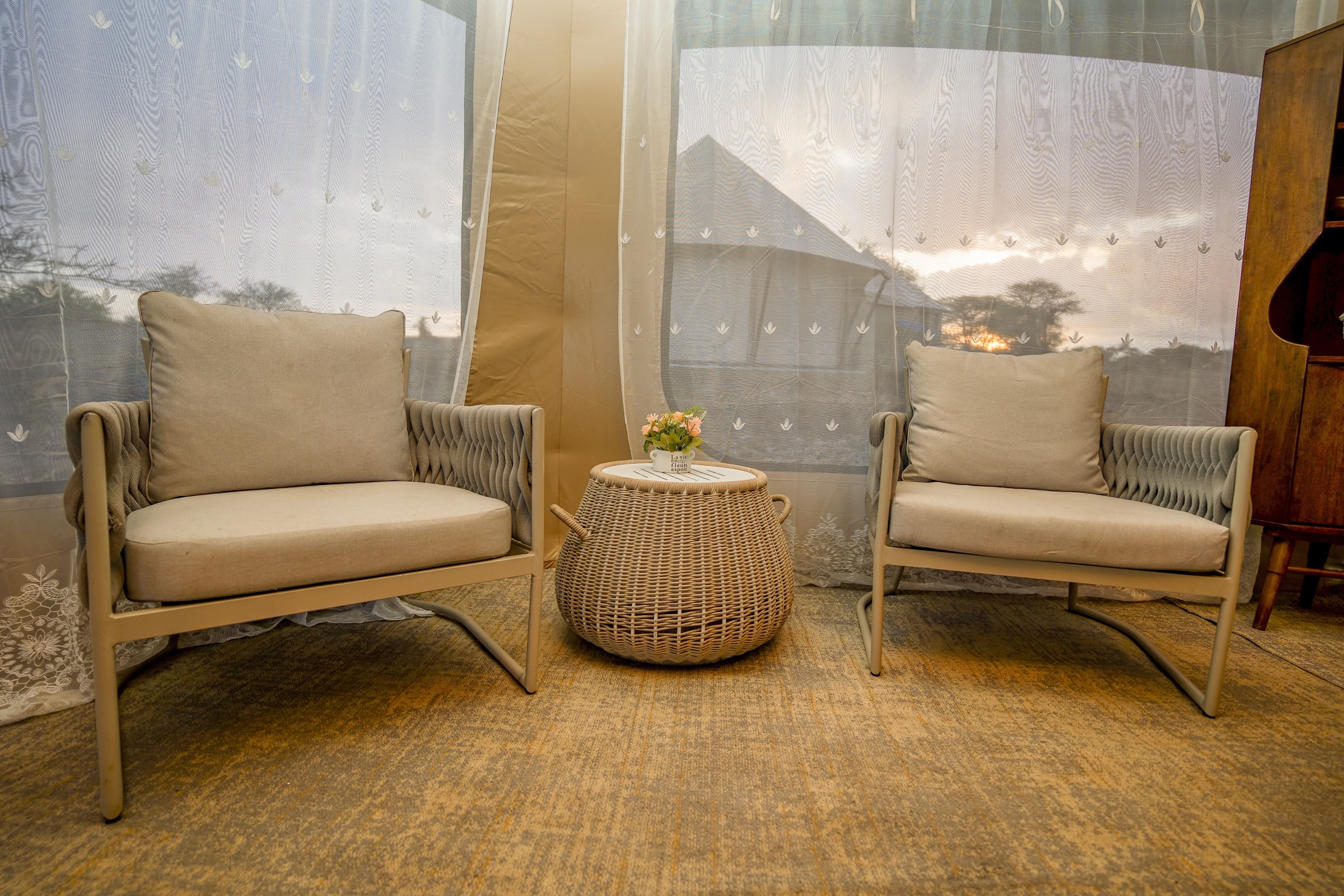 Main dining area with wooden tables and wicker chairs overlooking savanna landscape