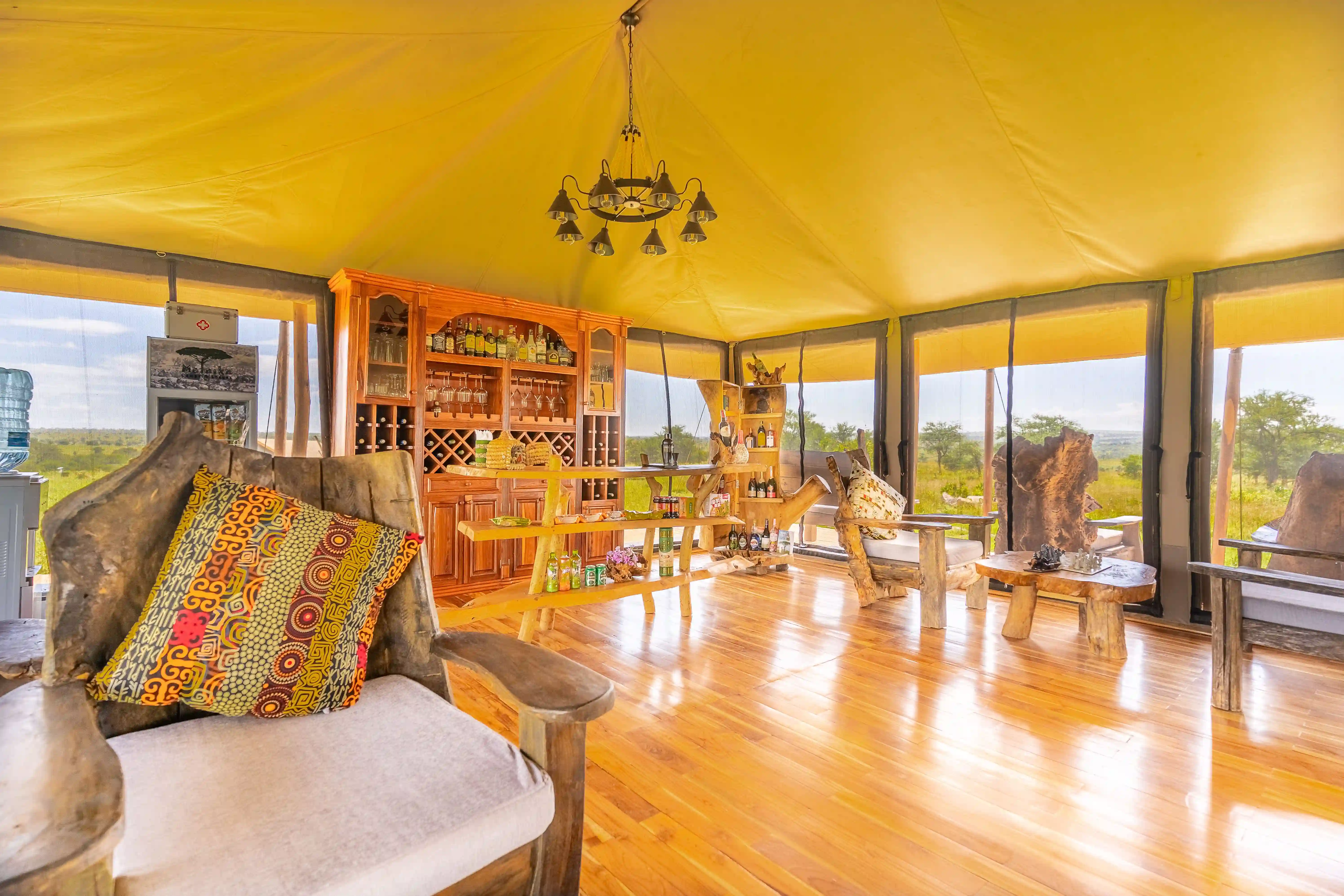 Seronera camp at twilight with illuminated tents and acacia tree